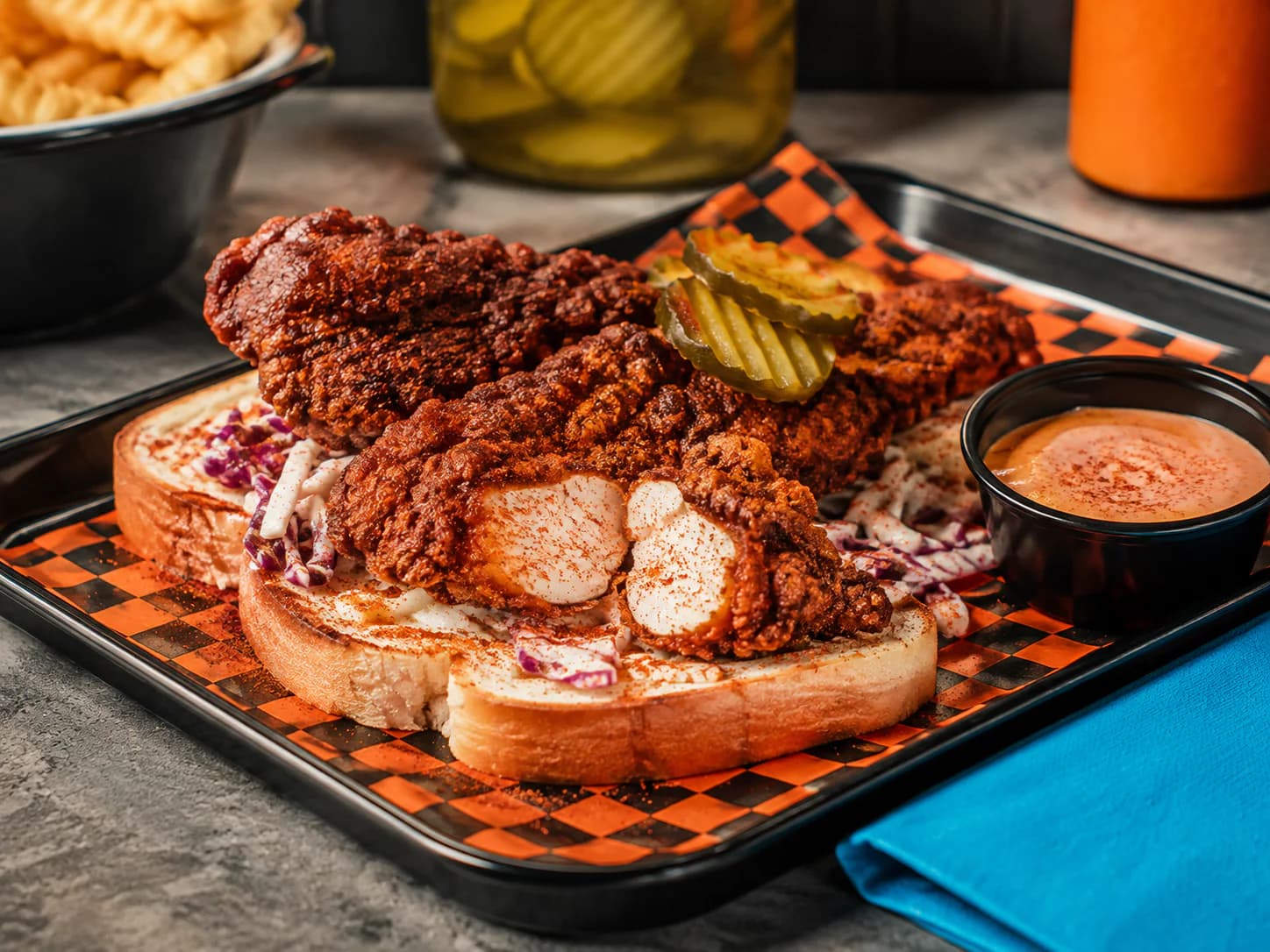 Nashville hot chicken tenders with creamy house slaw, pickles and toasted bread