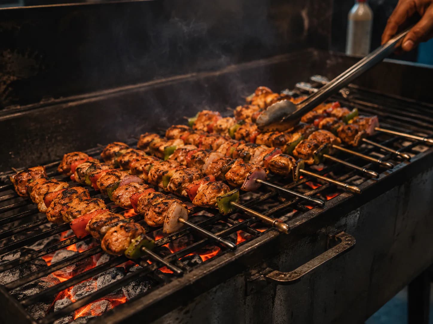 Chicken shish kebab skewers cooking over glowing charcoal