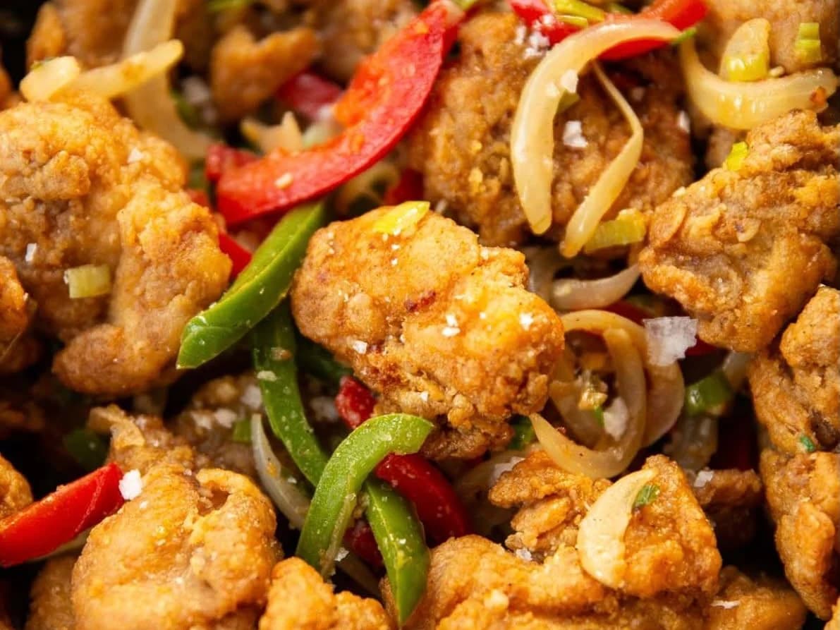 Cluckin' Salt N Pepper - crispy salt and pepper fried chicken pieces tossed with red and green peppers and onions, from Ashville Hot Chicken, JLT Dubai