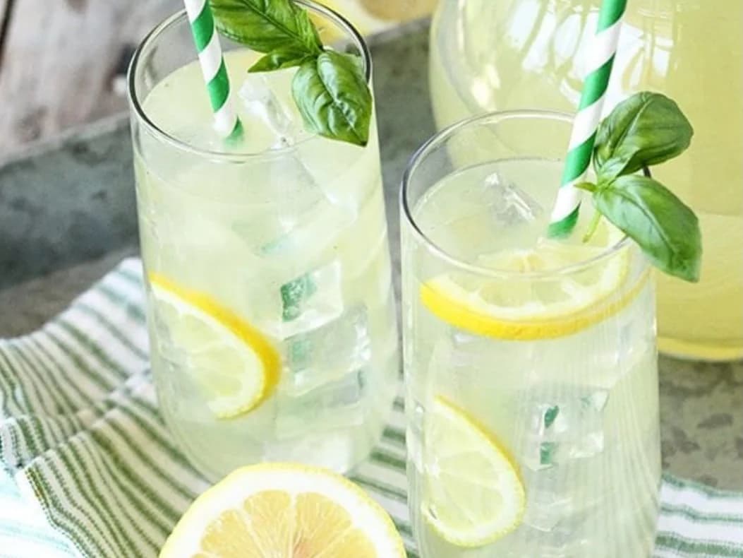 Lemonade - two tall glasses of fresh lemonade with lemon slices, basil and striped straws, from Ashville Hot Chicken, JLT Dubai